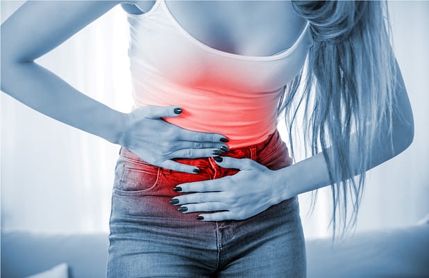 Young woman at home suffering from abdominal pain
